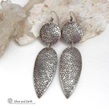 Bold, modern and contemporary - these long handcrafted sterling silver earrings feature an intricate hand textured design. They have an urban chic appeal and will look great with all wardrobe styles. They go with everything! Earrings are sturdy & substantial - yet lightweight and comfortable for all day wear.   MEASUREMENTS: Total length: 3" from top of sterling silver ear wires and 3/4” at widest point. Handmade in the USA by Silver and Earth Jewelry. 