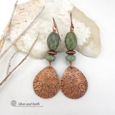 These handcrafted copper earrings have a hammered and hand stamped texture and are accented with green Russian serpentine stones. Russian serpentine is known for its unique natural patterns with light and dark green speckles and web-like patterns. They are accented with small, light green African turquoise stones and copper beads. Bold and unique, they have a boho chic flair and will make a striking statement. Handmade in the USA by Silver and Earth Jewelry.