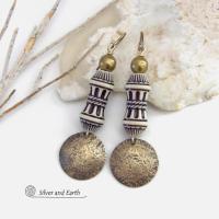 Bold and unique, these handcrafted earrings have an ethnic African tribal vibe. They feature gold brass dangles with a hammered rustic texture accented with exotic African beads with an intricate brown and white carved pattern topped off with gold brass beads. Unique and fun to wear - they'll make a bold, striking statement. Perfect for women that love to wear one-of-a-kind artisan handcrafted jewelry. Handmade in the USA by Silver and Earth Jewelry. 
