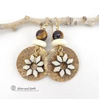 These handmade gold brass earrings have an ethnic bohemian style with an African inspired flair that makes a bold statement. They feature round brass dangles with a lightly hammered texture accented with African flower-shaped bone beads, faceted natural tiger's eye gemstones and African bone beads. Unique and fun to wear, they'll make a great gift for nature lovers and gardeners who love bohemian style jewelry.