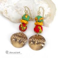 Bold and unique - these gold brass dangle earrings will surely brighten your day! They feature bright and colorful African glass beads with beautiful hues of green, red and yellow. They are accented with handcrafted gold brass dangles with a hammered organic texture. The African beads are handcrafted by artisans in Ghana from recycled glass by a traditional process passed down thru many generations. These earrings have a bohemian Afrocentric style with lots of fashionable flair! 