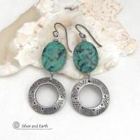 These handcrafted earrings feature natural African turquoise stones accented with silver tone pewter dangles with a hand stamped texture and oxidized finish. They have an earthy, modern style with a touch of southwestern flair. Matching necklace sold separately. Handmade in the USA by Silver and Earth Jewelry. 