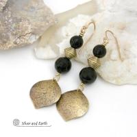 These handcrafted earrings feature gold brass dangles with a hammered raw silk texture accented with black onyx gemstones and brass beads. They have a modern boho chic style with a touch of Egyptian inspired flair that coordinates beautifully with all wardrobe types. Perfect for women that love artisan handcrafted jewelry that makes a bold statement. Handmade in the USA by Silver and Earth Jewelry. 