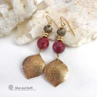 These handcrafted gold brass earrings have a hammered raw silk texture and are accented with micro-faceted burgundy mookaite gemstones, tiny brass beads and tulip flower-shaped beads. Mookaite is a unique, colorful type of jasper that is found at the Mooka Creek in Western Australia. It's known for distinct colors of burgundy, yellows, pinks, and purples. These earrings have a modern elegant chic style that coordinates beautifully with all wardrobe types. Handmade in the USA by Silver and Earth Jewelry. 