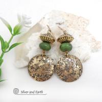 These handcrafted earrings feature round gold brass dangles with a lightly hammered organic texture accented with natural green serpentine gemstones and textured brass beads. They have an earthy elegant and modern style that coordinates beautifully with all wardrobe styles. Perfect for your spring wardrobe - or any time of year.These handcrafted earrings showcase a unique blend of textures and patterns, perfect for adding a touch of bohemian style to any outfit. 