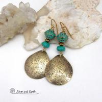 These handcrafted earrings have an elegant modern style with a tribal boho chic flair. They feature gold brass dangles with a hammered organic silky texture accented with faceted genuine turquoise gemstones, tiny brass beads and blue-green patina beads with a tribal style pattern. Bold and unique, they'll make a striking statement. Handmade in the USA by Silver and Earth Jewelry.