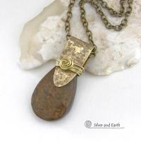 This handcrafted necklace features a natural bronzite gemstone accented with a gold brass bail. The stone has a beautiful chocolate brown hue with a subtle golden shimmer. Bronzite is a mineral that shares characteristics with rock that is found in meteorites, such as iron. It's this blend of several minerals which gives bronzite its unique mottled characteristic. The necklace has an earthy, modern style that coordinates beautifully with all wardrobe types. 