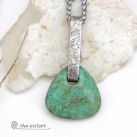 This one-of-a-kind pendant necklace features a beautiful chunky natural chrysocolla gemstone with a faceted finish. The stone is a beautiful shade of bluish-green which resembles turquoise. It hangs from a hand forged solid sterling silver bail with a lightly hammered organic texture. It's reversible. Unique and one-of-a-kind, it's sure to make a statement. Handmade in the USA by Silver and Earth Jewelry.