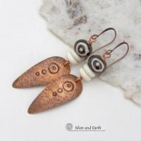 These handcrafted copper earrings have a lightly hammered and hand stamped texture and are accented with patterned African batik bone and off-white bone beads. Bold and striking, they have an ethnic tribal vibe and will make a unique statement. Your choice of ear wire - copper or hypoallergenic niobium. Handmade in the USA by Silver and Earth Jewelry.