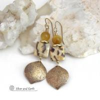 These handcrafted earrings feature shiny gold brass dangles with a hammered raw silk texture accented with graphic feldspar and golden tiger's eye gemstones and shiny brass beads. Graphic feldspar is a type of moonstone that has smoky quartz inclusions which creates unique natural patterns. They have an elegant, modern chic style that looks great dressed up or down. Handmade in the USA by Silver and Earth Jewelry. Total length of approx. 2-3/8" from top of brass ear wires and 3/4" at widest point.