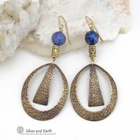 These long gold brass hoop earrings have a hand stamped texture and are accented with faceted blue lapis lazuli gemstones and brass beads. They have an exotic chic design that has an Egyptian inspired vibe and flair. Suitable for any occasion - they'll look great dressed up or down. Perfect for women that love to wear artisan handcrafted jewelry that makes a bold statement. Handmade in the USA by Silver and Earth Jewelry. 