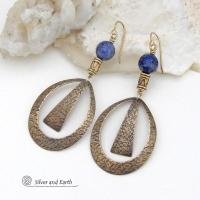 These long gold brass hoop earrings have a hand stamped texture and are accented with faceted blue lapis lazuli gemstones and brass beads. They have an exotic chic design that has an Egyptian inspired vibe and flair. Suitable for any occasion - they'll look great dressed up or down. Perfect for women that love to wear artisan handcrafted jewelry that makes a bold statement. Handmade in the USA by Silver and Earth Jewelry. 