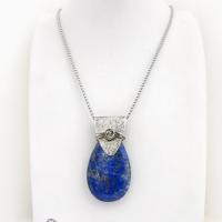This sterling silver necklace features a natural lapis lazuli gemstone accented with a handcrafted sterling silver bail with a lightly hammered organic texture. The lapis is a beautiful shade of blue with natural sparkly pyrite inclusions.