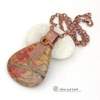 This one-of-a-kind necklace features a large stunning red creek jasper stone accented with a handcrafted copper bail. The stone has a natural pattern in beautiful earthy shades of brick red, orange and taupe with streaks of black veining. Big and bold, this necklace is a real statement piece - perfect for anyone that loves natural stones!