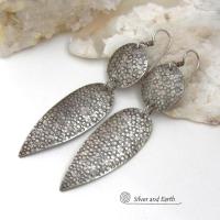 Bold, modern and contemporary - these long handcrafted sterling silver earrings feature an intricate hand textured design. They have an urban chic appeal and will look great with all wardrobe styles. They go with everything! Earrings are sturdy & substantial - yet lightweight and comfortable for all day wear.   MEASUREMENTS: Total length: 3" from top of sterling silver ear wires and 3/4” at widest point. Handmade in the USA by Silver and Earth Jewelry. 