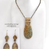 This handcrafted necklace features a natural Picasso jasper gemstone accented with a gold brass bail. The stone has a beautiful matrix with earthy hues of soft yellow, light mossy green and brown streaks. It has an earthy, modern style that coordinates beautifully with all wardrobe types. Unique and one of a kind, it makes a great gift for a natural stone lover - or a nice addition to your own jewelry collection. Comes on a 20" antiqued brass chain with lobster claw closure.  