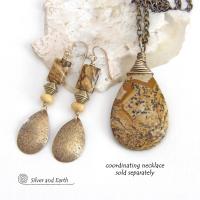These handcrafted earrings feature gold brass teardrop dangles with a lightly hammered organic texture accented with natural picture jasper stones, brass and fossilized beige coral beads. They have an earthy natural style that coordinates beautifully with all wardrobe styles. Earrings have a coordinating necklace sold separately. Handmade in the USA by Silver and Earth Jewelry.