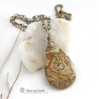 This one-of-a-kind necklace features a natural picture jasper stone wrapped in gold brass wire. The stone has an interesting matrix pattern with earthy hues of brown, tan and black. It has an earthy, simple style that coordinates beautifully with all wardrobe styles. It makes a great gift for a natural stone lover - or a nice addition to your own jewelry collection. Handmade in the USA by Silver and Earth Jewelry. Coordinating earrings sold separately.