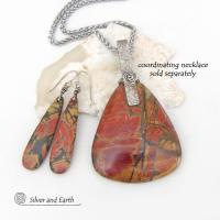 Full of earthy charm - these one-of-a-kind earrings feature long natural red creek jasper stones dangling from sterling silver ear wires. The stones have a beautiful natural pattern in earthy hues of mossy greens, brick red, orange and subtle hints of golden yellow. They'll make a great gift for anyone that loves natural stones! Matching necklace available. 