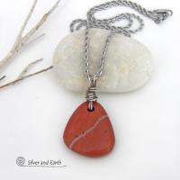 Simple and earthy - this pendant necklace features a natural red jasper gemstone with a wire wrapped sterling silver bail. The stone has a brick red hue with a natural matrix of beige streaks and dots. It has a modern minimalist appeal and is perfect for those that prefer simple, earthy jewelry that coordinates well with all wardrobe styles. It makes a great gift for a natural stone lover - or a nice addition to your own jewelry wardrobe. Handmade in the USA by Silver and Earth Jewelry. 