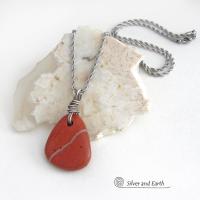 Simple and earthy - this pendant necklace features a natural red jasper gemstone with a wire wrapped sterling silver bail. The stone has a brick red hue with a natural matrix of beige streaks and dots. It has a modern minimalist appeal and is perfect for those that prefer simple, earthy jewelry that coordinates well with all wardrobe styles. It makes a great gift for a natural stone lover - or a nice addition to your own jewelry wardrobe. Handmade in the USA by Silver and Earth Jewelry. 