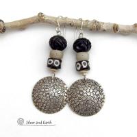 These handcrafted sterling silver earrings have an ethnic, tribal vibe. They feature African carved bone, glass and batik bone beads accented with hand stamped sterling silver dangles. Bold and striking, they'll make an exotic statement. Perfect for women that love to wear unique jewelry. Handmade in the USA by Silver and Earth Jewelry. 