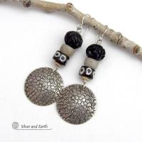 These handcrafted sterling silver earrings have an ethnic, tribal vibe. They feature African carved bone, glass and batik bone beads accented with hand stamped sterling silver dangles. Bold and striking, they'll make an exotic statement. Perfect for women that love to wear unique jewelry. Handmade in the USA by Silver and Earth Jewelry. 