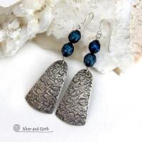 These sterling silver earrings feature handcrafted sterling silver dangles with an intricate hand stamped texture accented with deep teal blue freshwater pearls with a faceted finish.  They have a modern, elegant feel and will look great dressed up or down. They dangle from sterling silver ear wires. Handmade in the USA by Silver and Earth Jewelry. 