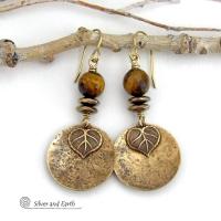 These handcrafted earrings feature gold brass dangles with a lightly hammered texture accented with natural tiger's eye gemstones, brass leaf charms and faceted hematite stones with a sparkly electroplated gold tone finish. The tiger's eye stones also have a faceted cut which casts off a beautiful natural sparkle and shine. They have a modern, elegant chic style that coordinates with all wardrobe styles. Makes a great gift for a nature lover - or a nice addition to your own jewelry wardrobe. 