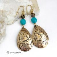 These handcrafted gold brass teardrop dangle earrings have a hand stamped texture accented with natural turquoise gemstones with a faceted finish and tulip flower-shaped brass beads. Big, long and striking - they have a modern elegant boho chic style that makes a bold statement. They'll coordinate beautifully with all wardrobe types - dressed up or down. Handmade in the USA by Silver and Earth Jewelry. 