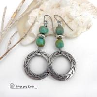 These handcrafted earrings feature silver pewter hoops with a hand stamped texture accented with natural, genuine turquoise stones and silver plated beads. Lightweight and comfortable to wear, they have an earthy modern style with southwest flair that coordinates beautifully with all wardrobe types. Handmade in the USA by Silver and Earth Jewelry, a Certified New Mexico True business.