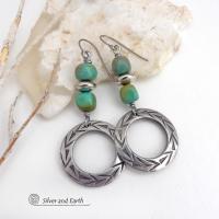 These handcrafted earrings feature silver pewter hoops with a hand stamped texture accented with natural, genuine turquoise stones and silver plated beads. Lightweight and comfortable to wear, they have an earthy modern style with southwest flair that coordinates beautifully with all wardrobe types. Handmade in the USA by Silver and Earth Jewelry, a Certified New Mexico True business.