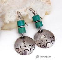 These handcrafted earrings feature silver pewter dangles with a hand stamped texture accented with natural turquoise stones and stainless steel spacer beads. They have a bold modern style with southwestern flair and will make a unique striking statement. They'll make a great gift for anyone that loves turquoise stones and southwest style jewelry. Handmade in the USA by Silver and Earth Jewelry.