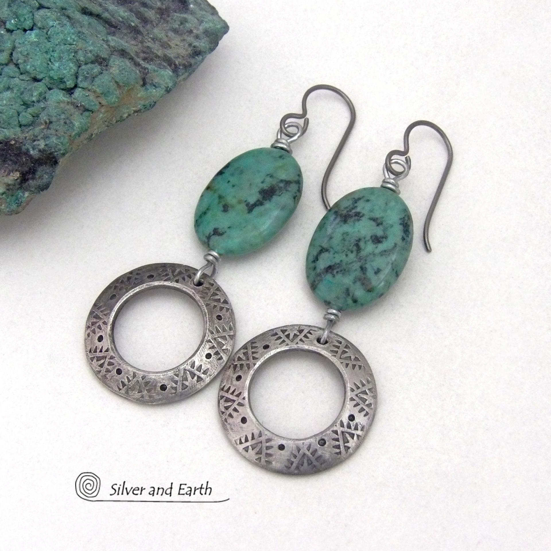 These handcrafted earrings feature natural African turquoise stones accented with silver tone pewter dangles with a hand stamped texture and oxidized finish. They have an earthy, modern style with a touch of southwestern flair. Matching necklace sold separately. Handmade in the USA by Silver and Earth Jewelry. 