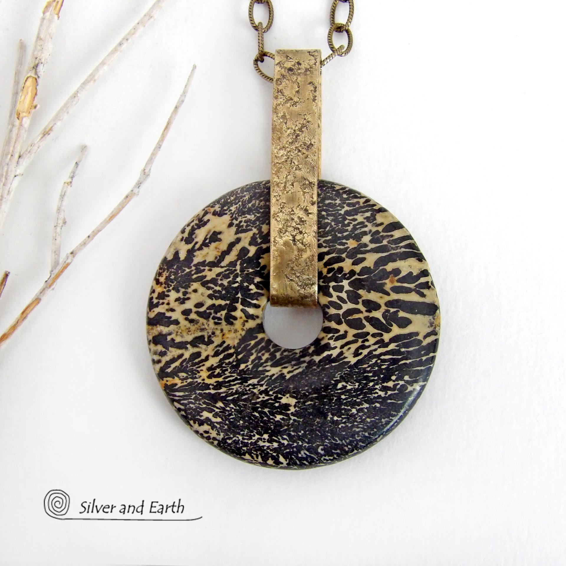 This one-of-a-kind pendant necklace features a stunning artistic jasper stone accented with a hand forged gold brass bail. This type of jasper is known for its intricate, natural patterns that resemble brushstrokes, landscapes, or abstract art. The stone in this piece has a natural bold dramatic pattern in hues of black and soft golden yellow with black streaks that resemble "feathery" dendrites. The design is modern and bold - yet classic and always in fashion. It can be worn by either a man or women. 