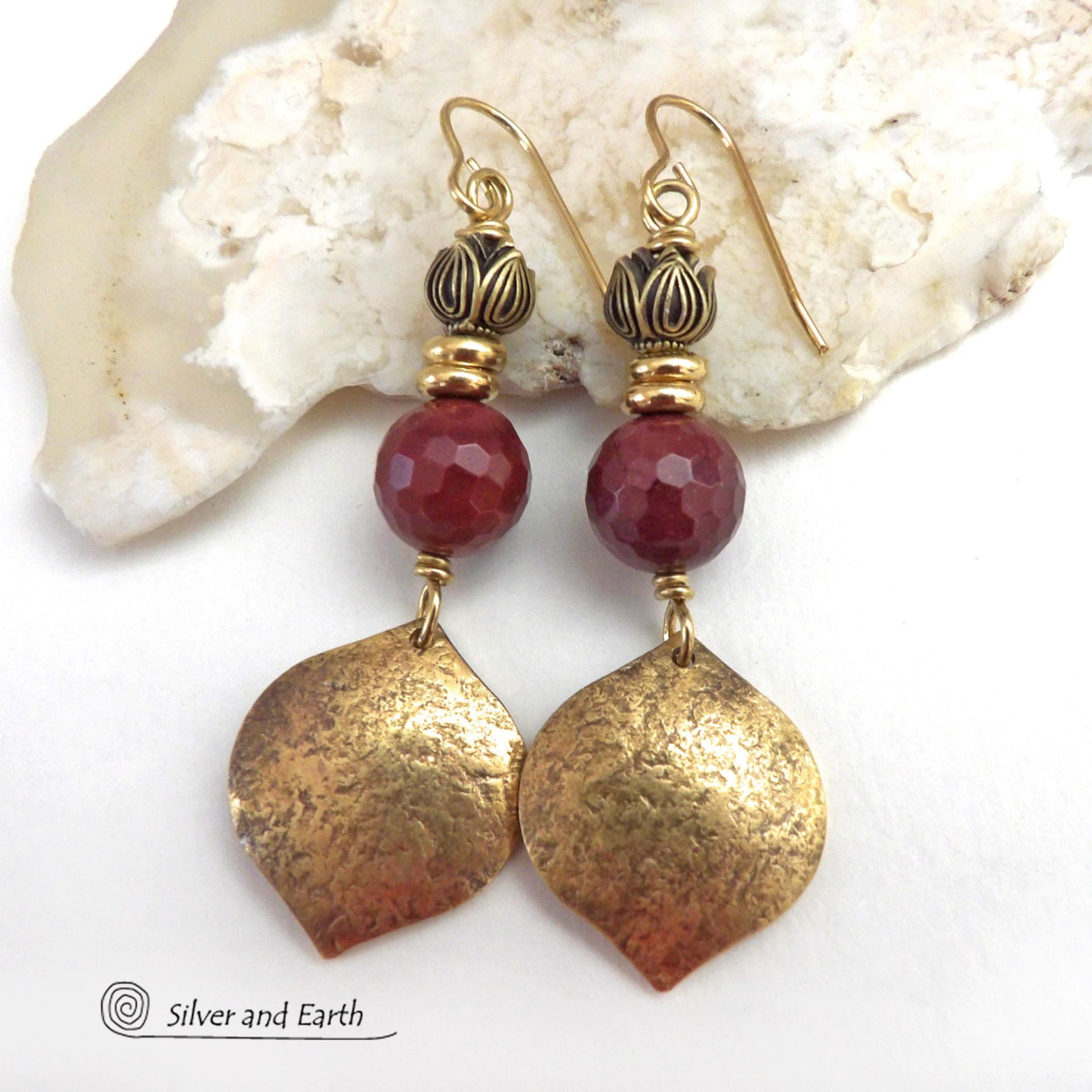 These handcrafted gold brass earrings have a hammered raw silk texture and are accented with micro-faceted burgundy mookaite gemstones, tiny brass beads and tulip flower-shaped beads. Mookaite is a unique, colorful type of jasper that is found at the Mooka Creek in Western Australia. It's known for distinct colors of burgundy, yellows, pinks, and purples. These earrings have a modern elegant chic style that coordinates beautifully with all wardrobe types. Handmade in the USA by Silver and Earth Jewelry. 