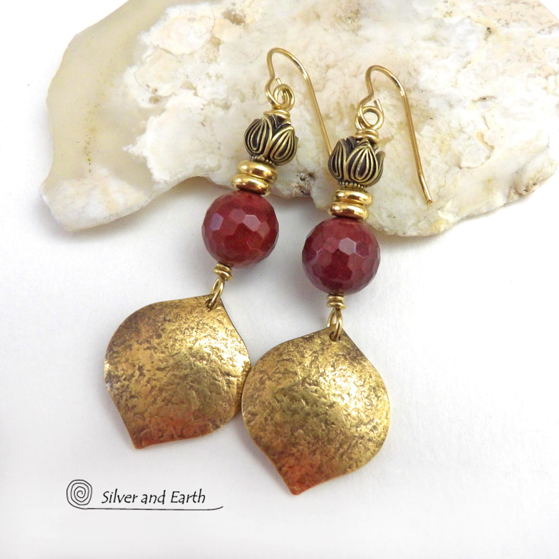 These handcrafted gold brass earrings have a hammered raw silk texture and are accented with micro-faceted burgundy mookaite gemstones, tiny brass beads and tulip flower-shaped beads. Mookaite is a unique, colorful type of jasper that is found at the Mooka Creek in Western Australia. It's known for distinct colors of burgundy, yellows, pinks, and purples. These earrings have a modern elegant chic style that coordinates beautifully with all wardrobe types. Handmade in the USA by Silver and Earth Jewelry. 