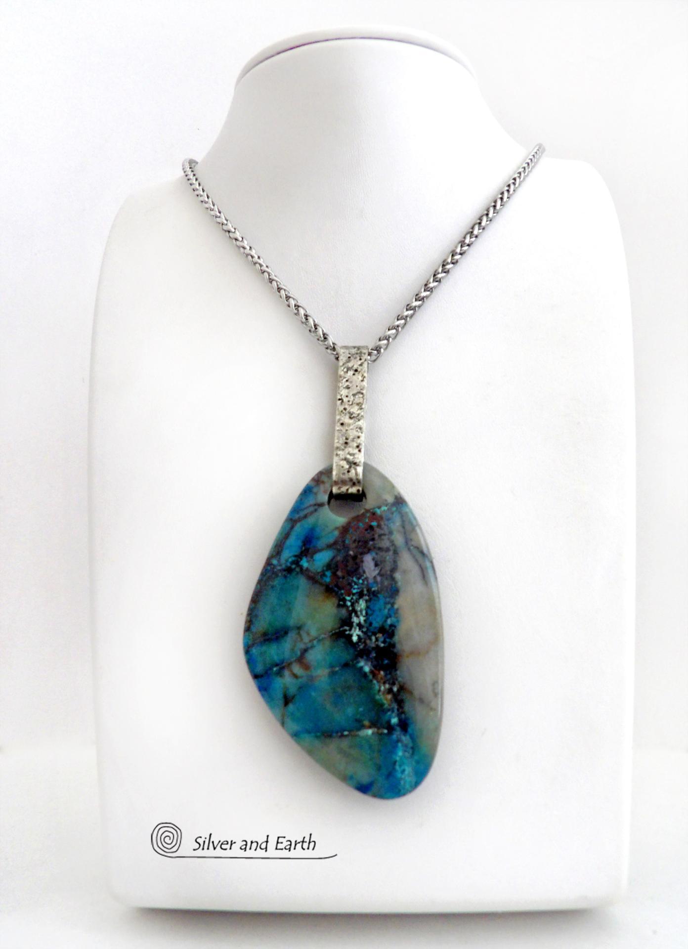 This one-of-a-kind necklace features a gorgeous, large chunky chrysocolla in quartz gemstone. The stone has beautiful shades of blue and brown within a quartz base. It hangs from a hand forged solid sterling silver bail with a lightly hammered organic texture. The stone is equally gorgeous on both sides, so I designed it to be reversible. (See all photos for alternate sides). Big and bold, it's sure to make a statement. Makes a great gift for a natural stone lover - or a nice addition to your own jewelry wa