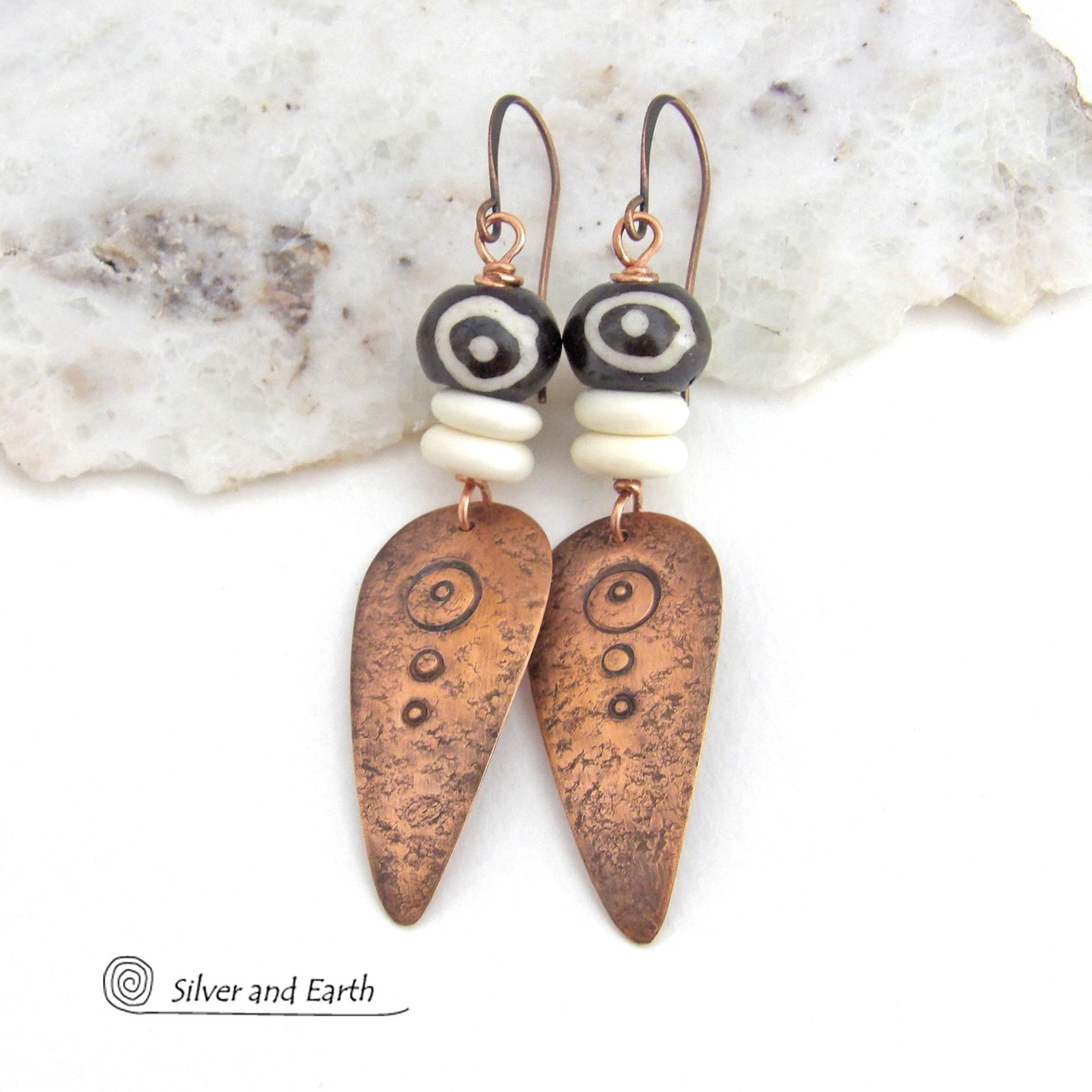 These handcrafted copper earrings have a lightly hammered and hand stamped texture and are accented with patterned African batik bone and off-white bone beads. Bold and striking, they have an ethnic tribal vibe and will make a unique statement. Your choice of ear wire - copper or hypoallergenic niobium. Handmade in the USA by Silver and Earth Jewelry.