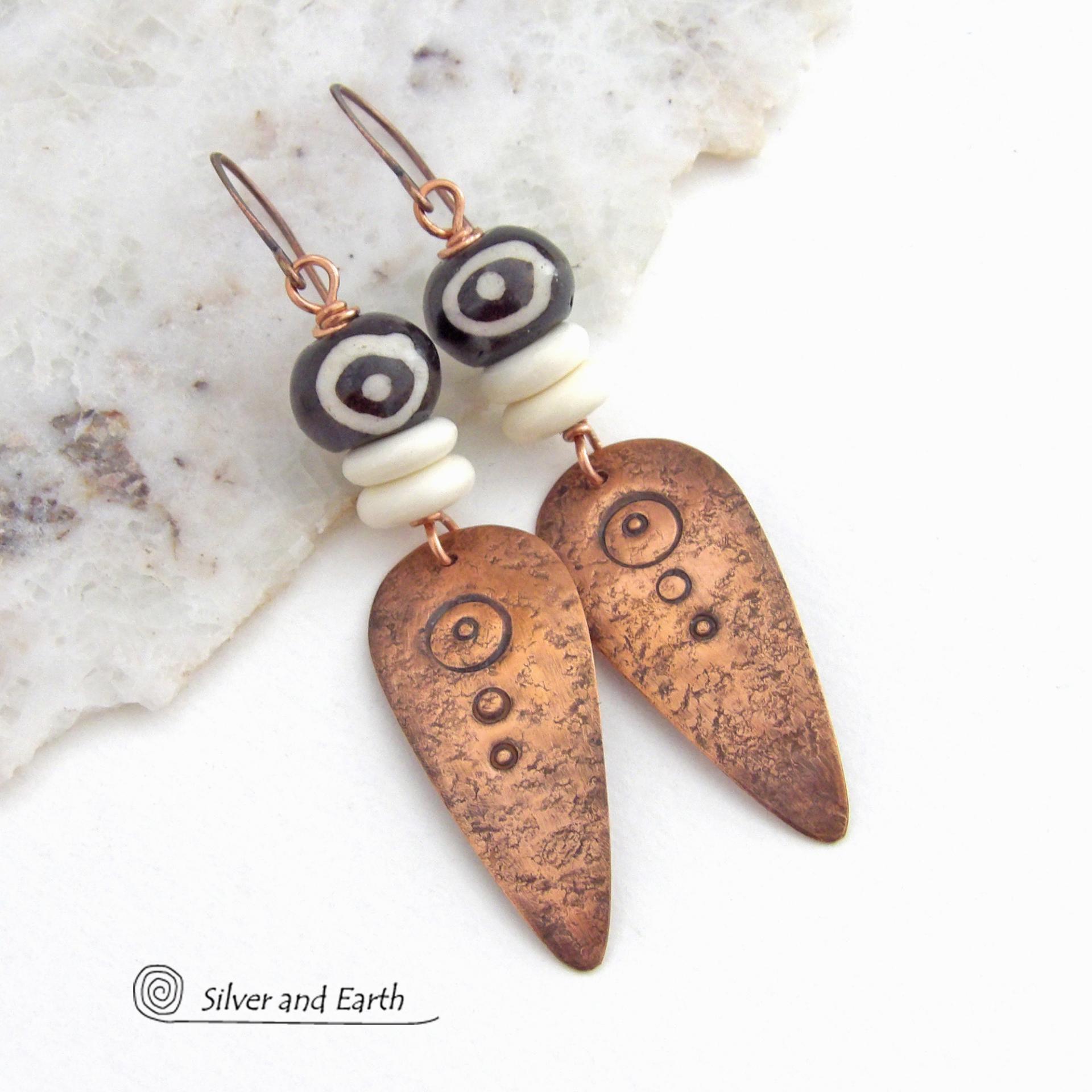 These handcrafted copper earrings have a lightly hammered and hand stamped texture and are accented with patterned African batik bone and off-white bone beads. Bold and striking, they have an ethnic tribal vibe and will make a unique statement. Your choice of ear wire - copper or hypoallergenic niobium. Handmade in the USA by Silver and Earth Jewelry.