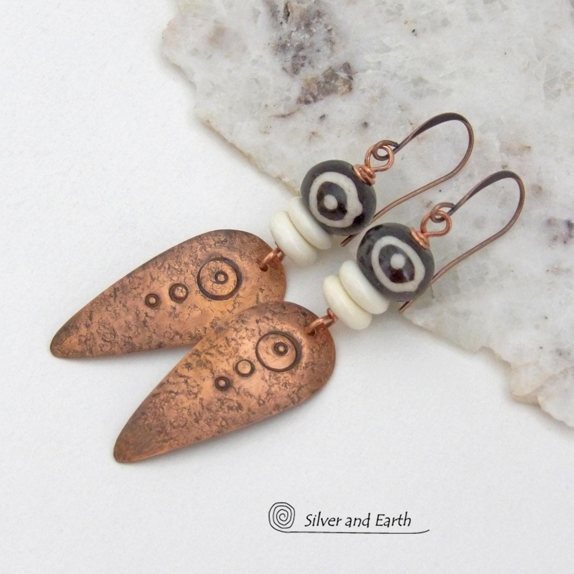 These handcrafted copper earrings have a lightly hammered and hand stamped texture and are accented with patterned African batik bone and off-white bone beads. Bold and striking, they have an ethnic tribal vibe and will make a unique statement. Your choice of ear wire - copper or hypoallergenic niobium. Handmade in the USA by Silver and Earth Jewelry.
