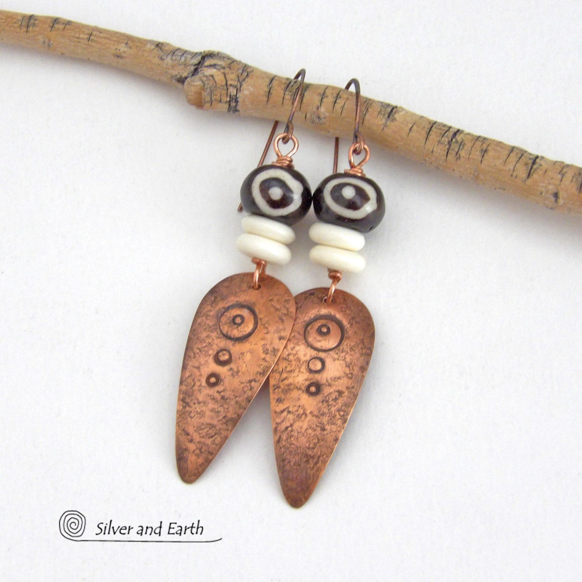 These handcrafted copper earrings have a lightly hammered and hand stamped texture and are accented with patterned African batik bone and off-white bone beads. Bold and striking, they have an ethnic tribal vibe and will make a unique statement. Your choice of ear wire - copper or hypoallergenic niobium. Handmade in the USA by Silver and Earth Jewelry.