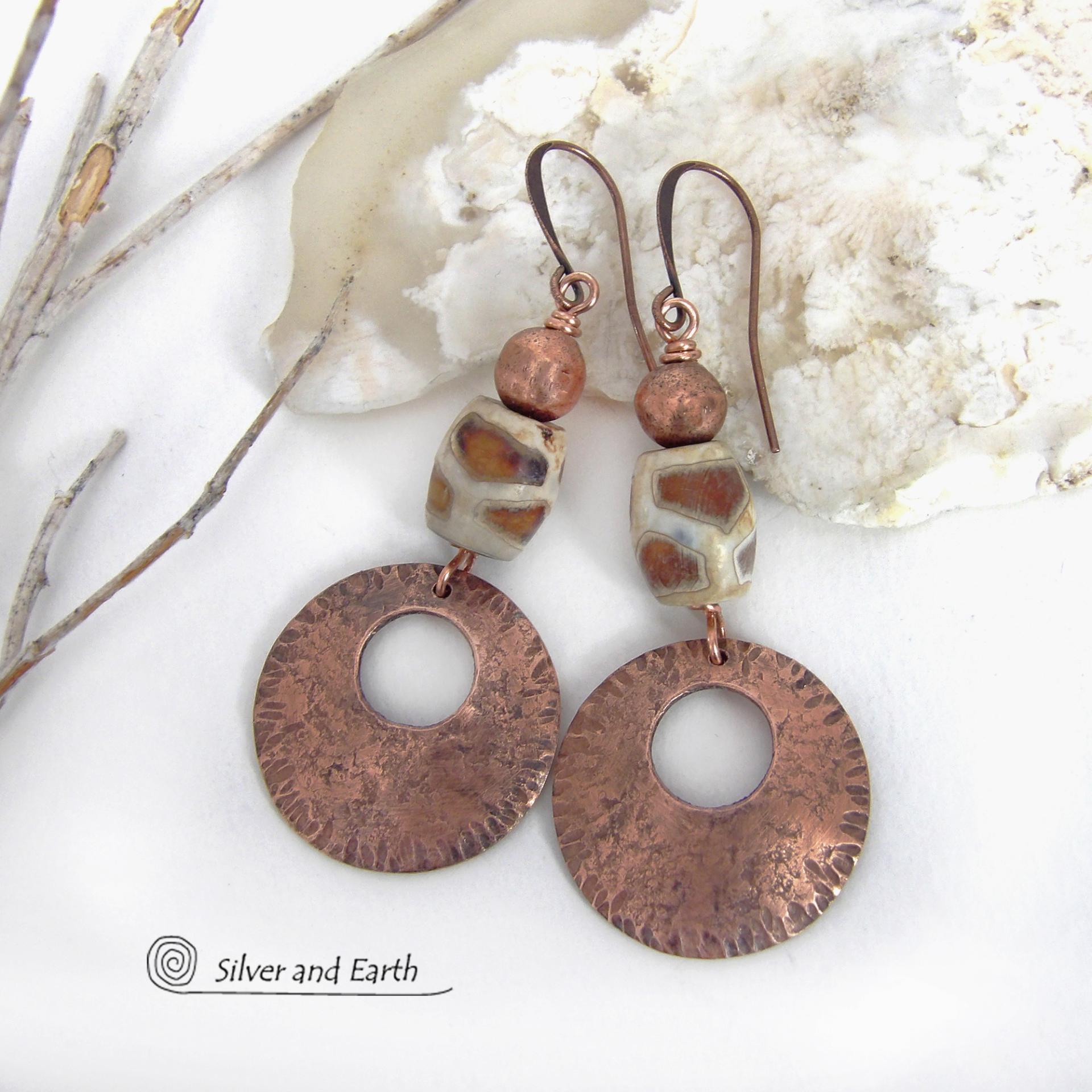 These handcrafted copper earrings have a bold, ethnic African style and flair. They feature round copper dangles with a rustic hammered texture accented with African etched giraffe print agate stones topped off with solid copper beads. Unique and striking, they'll make a bold statement. Handmade in the USA by Silver and Earth Jewelry. 