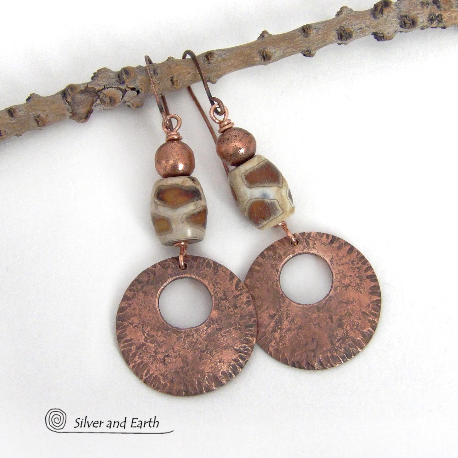 These handcrafted copper earrings have a bold, ethnic African style and flair. They feature round copper dangles with a rustic hammered texture accented with African etched giraffe print agate stones topped off with solid copper beads. Unique and striking, they'll make a bold statement. Perfect for women that love ethnic tribal style jewelry. Handmade in the USA by Silver and Earth Jewelry. 