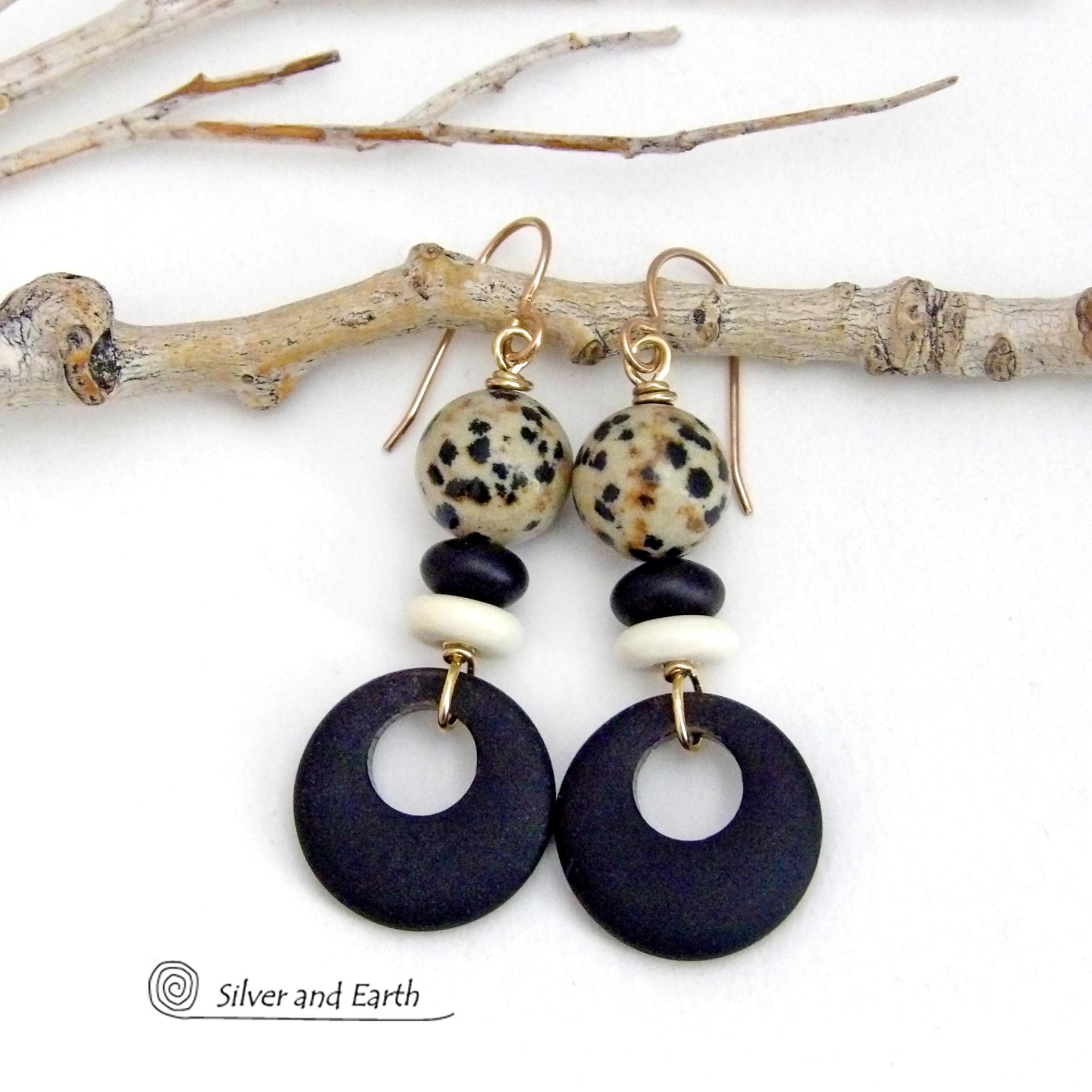 These handcrafted earrings feature matte black glass circle hoops accented with Dalmatian jasper gemstones, African bone and black glass beads. Unique and fun to wear, they have an earthy natural style with boho chic flair that makes a striking statement. They'll make a great gift for a natural stone lover - or a nice addition to your own jewelry wardrobe. Handmade in the USA by Silver and Earth Jewelry. 