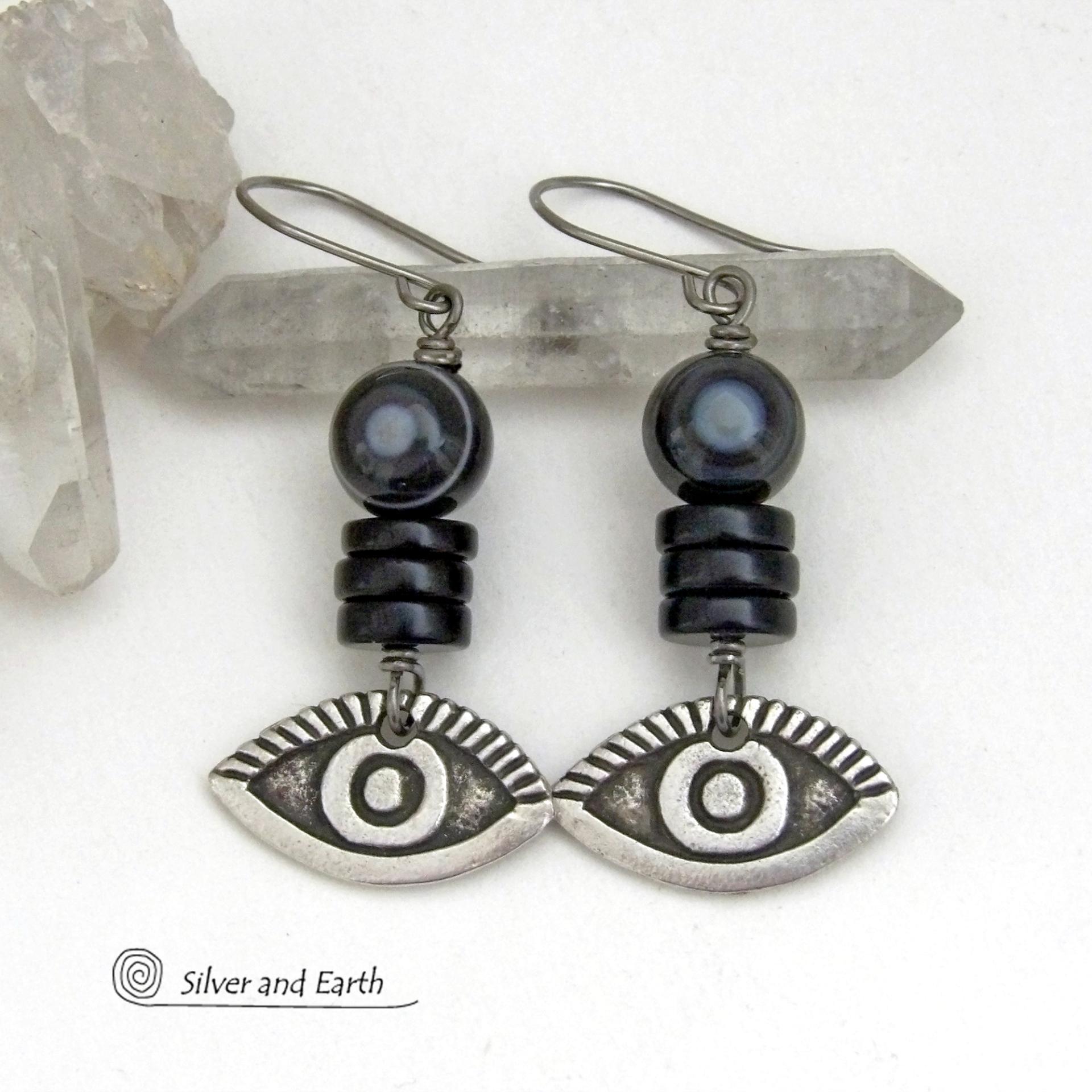 These unique earrings feature black eye agate and onyx stones accented with silver pewter "evil eye" charms. When cut at the right angle, this type of agate reveals a series of concentric rings that resembles the human eye. Evil eye symbolism has been around for centuries. The belief is that when worn -- evil eye jewelry will provide a level of protection against the envy and negative energy of others and perhaps bring the wearer good luck.
