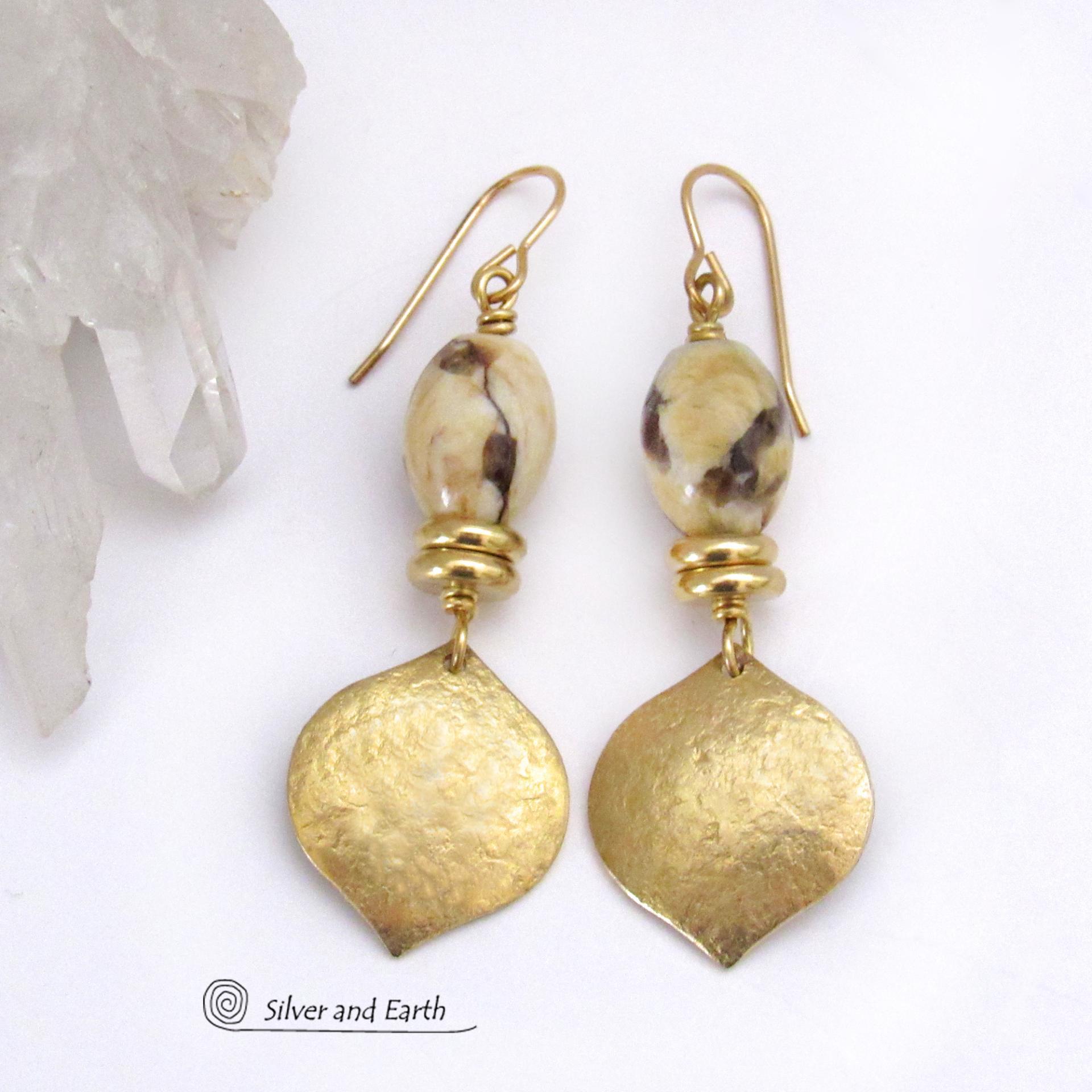These handcrafted earrings feature shiny gold brass dangles with a hammered raw silk texture accented with graphic feldspar gemstones and shiny brass beads. Graphic feldspar is a type of moonstone that has smoky quartz inclusions which creates unique natural patterns. They have an elegant, modern chic style that looks great dressed up or down. 