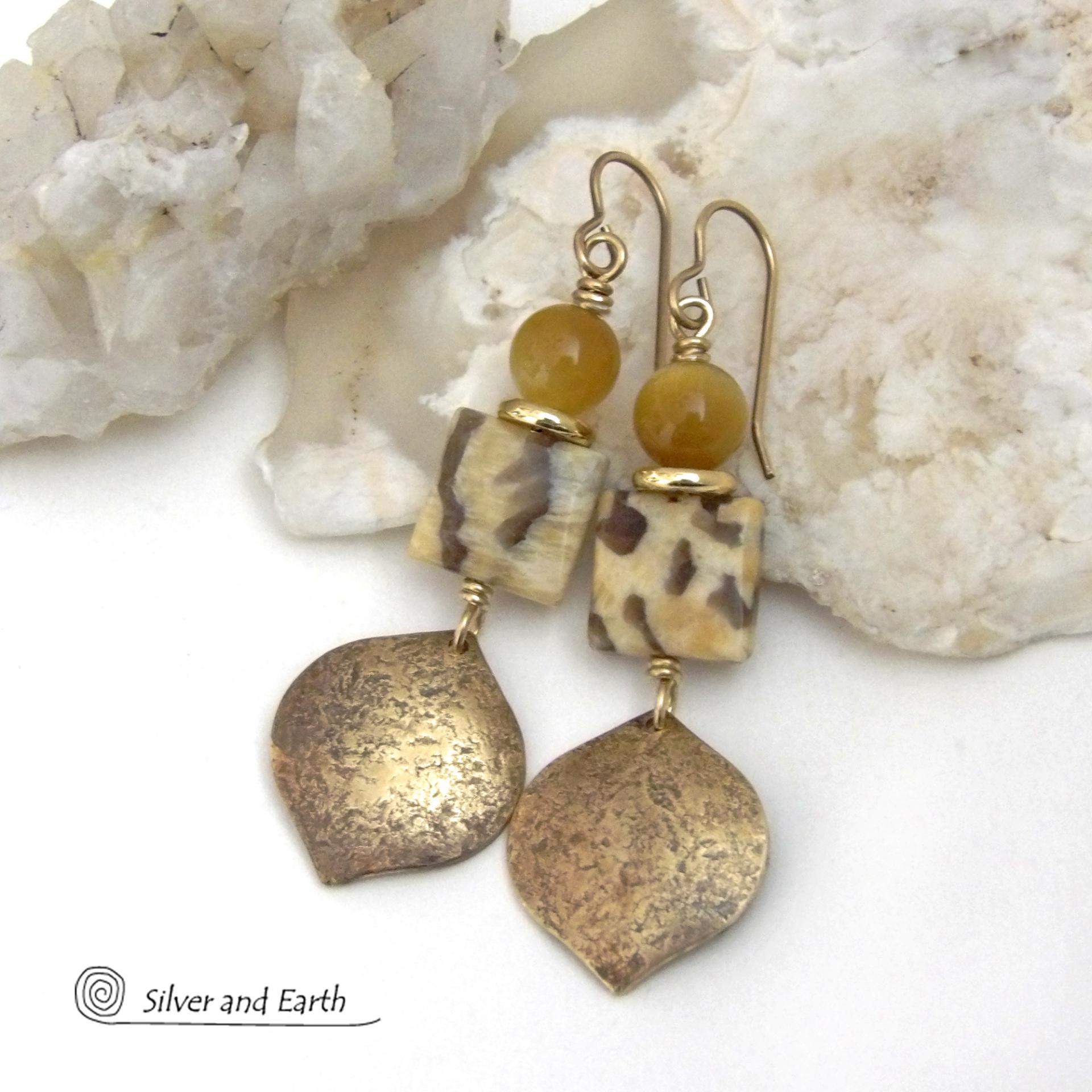 These handcrafted earrings feature shiny gold brass dangles with a hammered raw silk texture accented with graphic feldspar and golden tiger's eye gemstones and shiny brass beads. Graphic feldspar is a type of moonstone that has smoky quartz inclusions which creates unique natural patterns. They have an elegant, modern chic style that looks great dressed up or down. Handmade in the USA by Silver and Earth Jewelry. Total length of approx. 2-3/8" from top of brass ear wires and 3/4" at widest point.