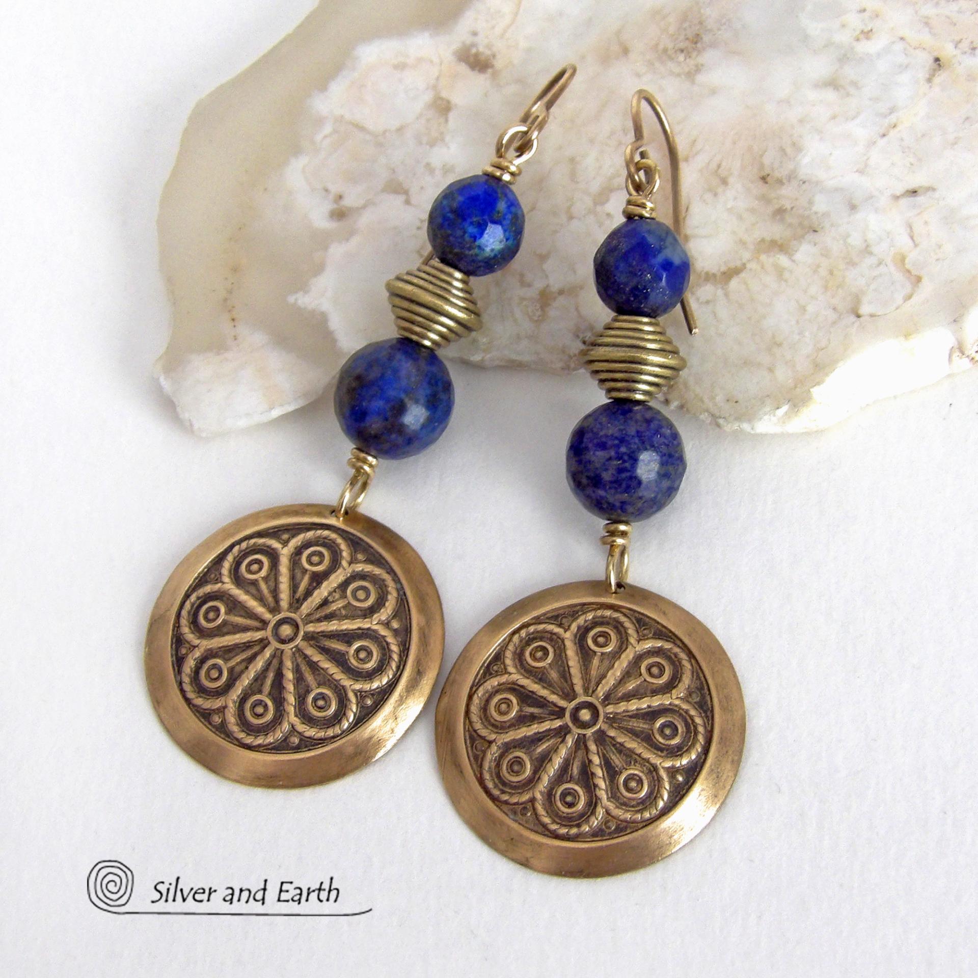 These handcrafted gold brass earrings have an exotic, Egyptian inspired vibe. They feature brass circle dangles with a beautiful embossed texture accented with faceted genuine lapis lazuli gemstones and textured brass beads. Bold and unique, they'll add a touch of cultural exotic charm to any type of wardrobe - dressed up or down. Perfect for women that love unique artisan handcrafted jewelry. Handmade in the USA by Silver and Earth Jewelry. 