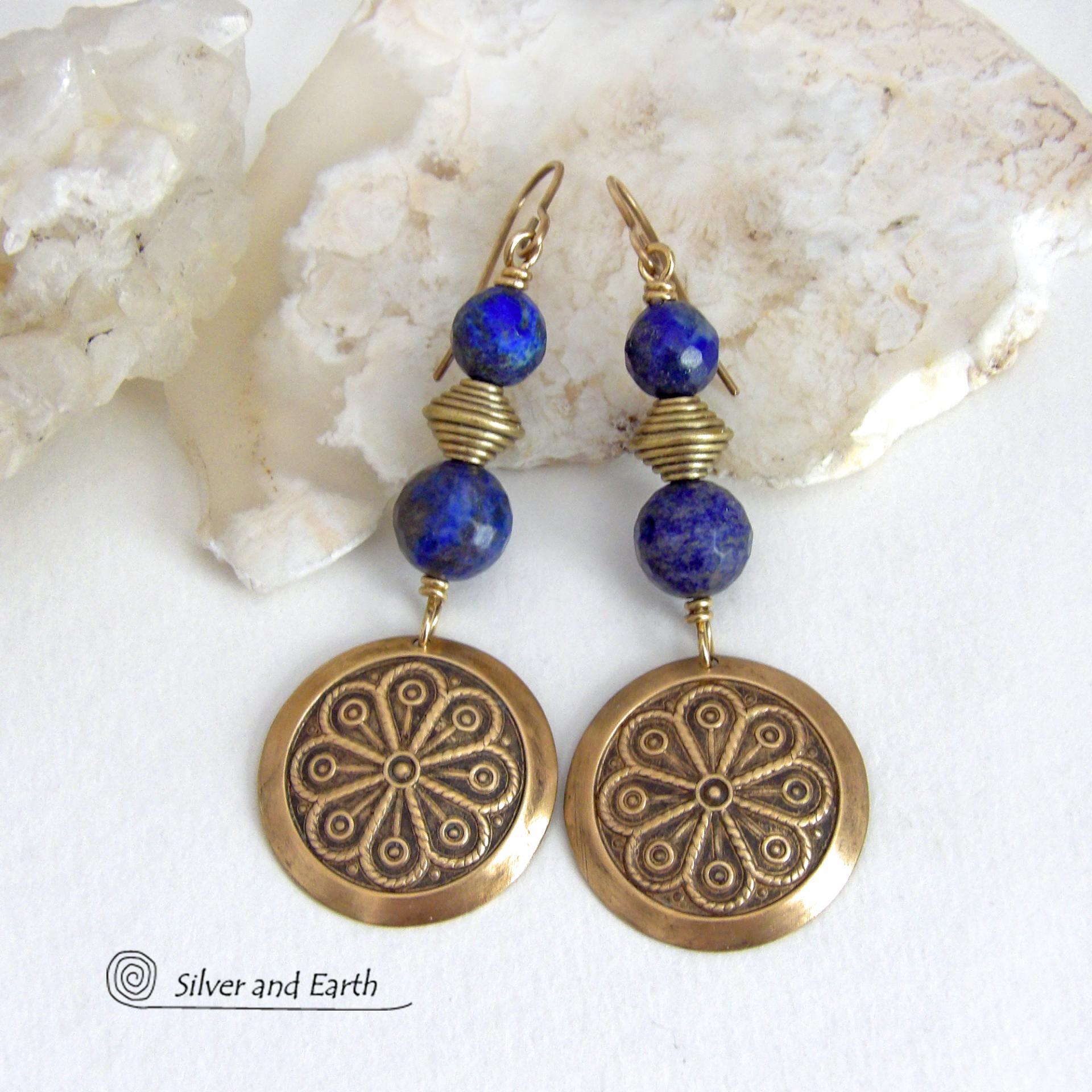 These handcrafted gold brass earrings have an exotic, Egyptian inspired vibe. They feature brass circle dangles with a beautiful embossed texture accented with faceted genuine lapis lazuli gemstones and textured brass beads. Bold and unique, they'll add a touch of cultural exotic charm to any type of wardrobe - dressed up or down. Perfect for women that love unique artisan handcrafted jewelry. Handmade in the USA by Silver and Earth Jewelry. 